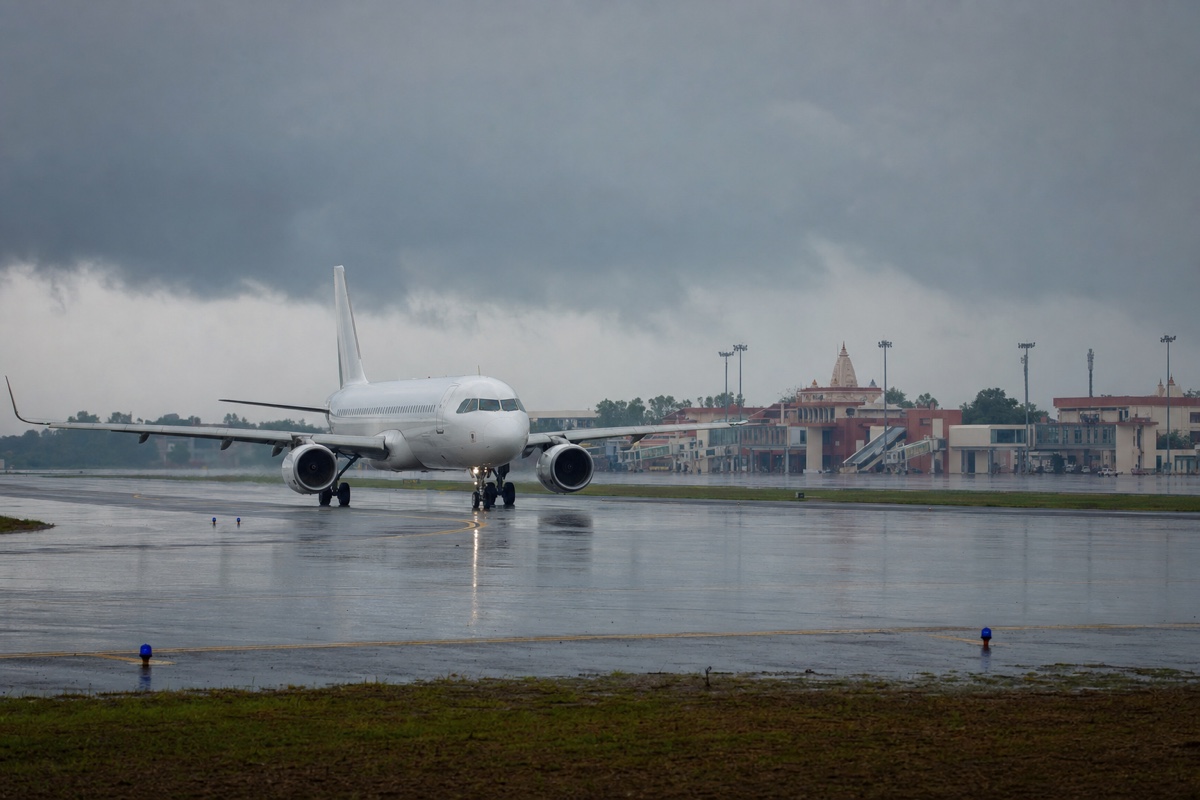 Passenger aircraft on a wet runway at Varanasi airport under monsoon clouds