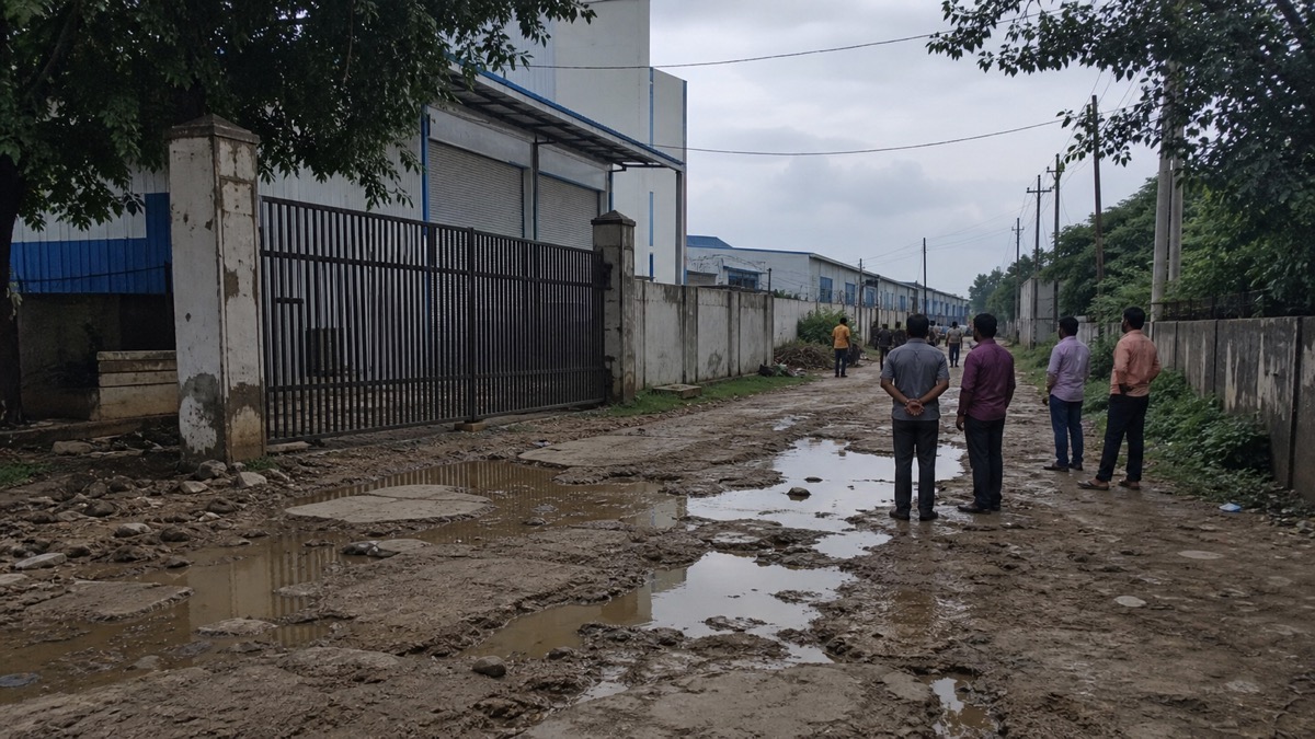Broken and waterlogged industrial access road outside a factory in Karkhiyaon