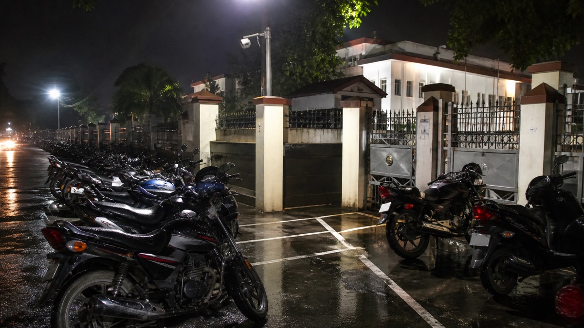 Motorcycle parking area inside a police campus under CCTV at night