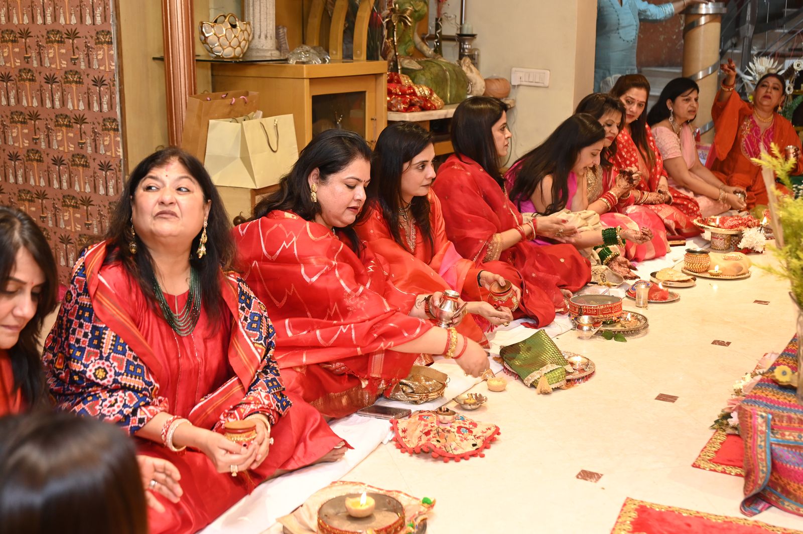 Women seated around the puja arrangement Karwa Chauth get-together, Varanasi