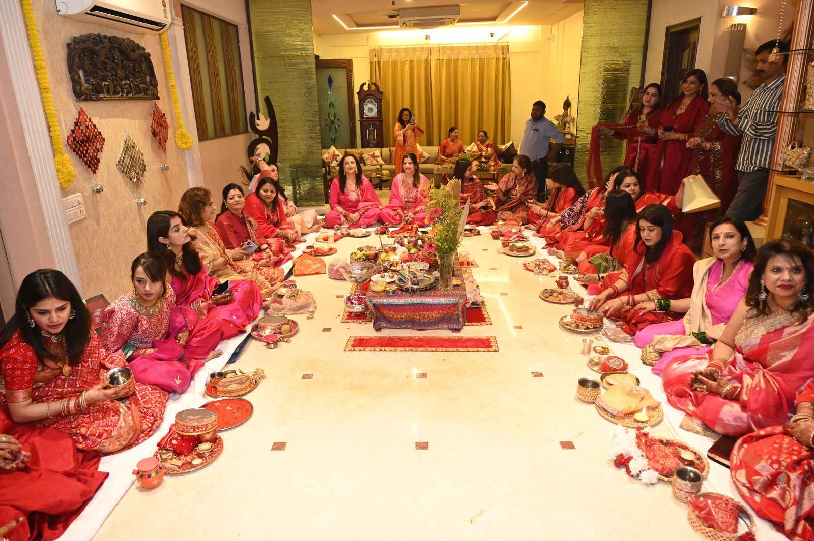 Women seated around the puja arrangement, Karwa Chauth get-together, Varanasi