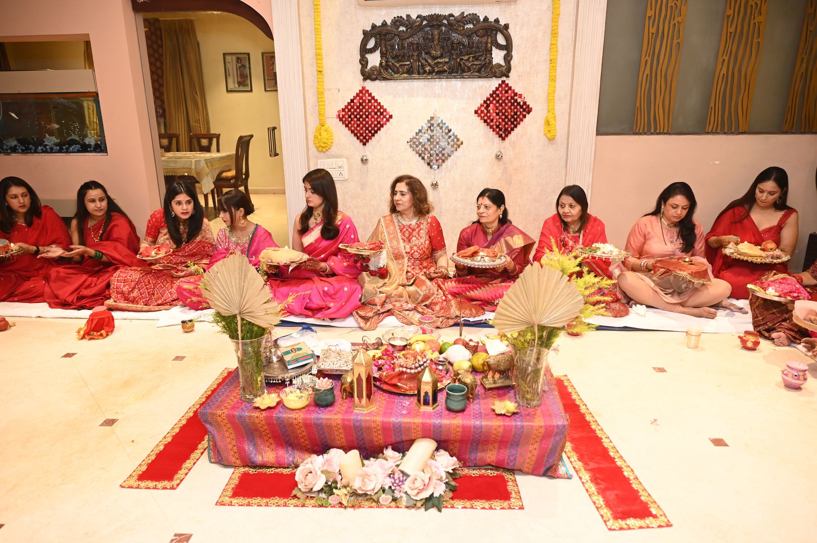 Women seated around the puja arrangement, Karwa Chauth get-together, Varanasi